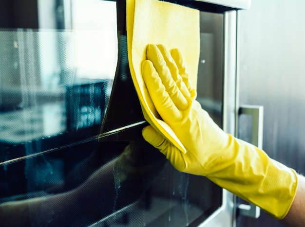 Man mano che pulisce il forno della cucina