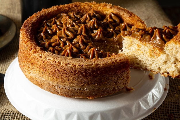 Man mano che taglia una fetta di tipica torta churros brasiliana con dulce de leche su un tavolo