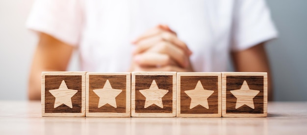 Man mano che tiene il blocco stella Il cliente sceglie la valutazione per le recensioni degli utenti Classifica della valutazione del servizio Valutazione della soddisfazione delle recensioni dei clienti e concetto di feedback