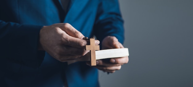 Man mano Sacra Bibbia e croce di legno