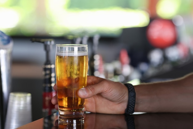 Man mano tenere un bicchiere di birra fredda. Servizio visitatori al bar.