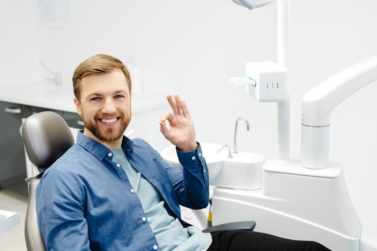 Man's smile is perfect Portrait of happy patient in dental chair after appointment