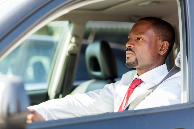 Manager africano maturo alla guida della sua auto