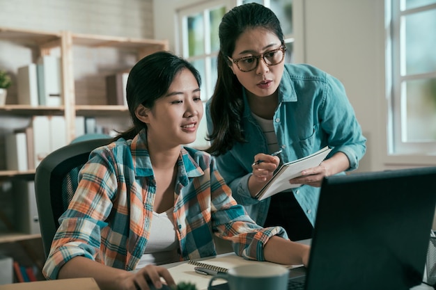 manager donna che discute di lavoro con una collega. Due soci d'affari che lavorano insieme in un ufficio luminoso e parlano del piano di relazione aziendale guardando il PC notebook. giovani ragazze colleghe.