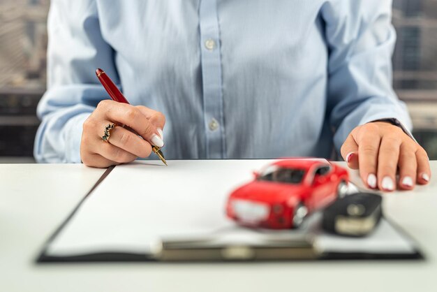 Manager donna seduta a una scrivania con documenti macchine da scrivere chiavi e tastiera auto e assicurazione sulla vita per i conducenti una donna in ufficio Desktop