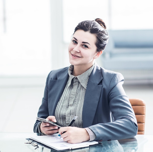 Manager Finance alla sua scrivania in un ufficio luminoso. La foto ha uno spazio vuoto per il tuo testo