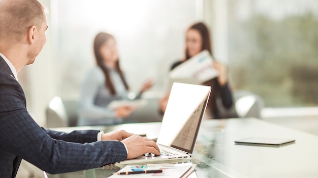 manager finanziari che lavorano su laptop con dati finanziari