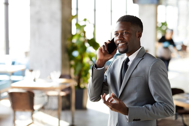 Manager nero positivo che parla al telefono