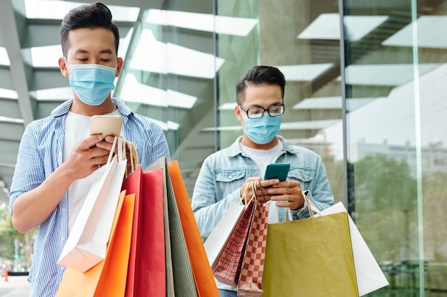 Mandare messaggi ai giovani con maschere mediche che camminano all'aperto dopo lo shopping