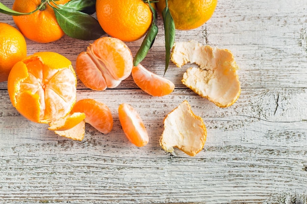 Mandarini arancio con le foglie verdi su legno bianco