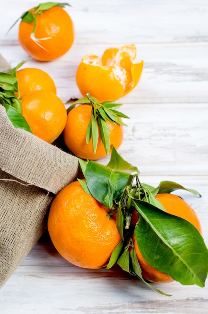 Mandarini con le foglie sulla tavola bianca