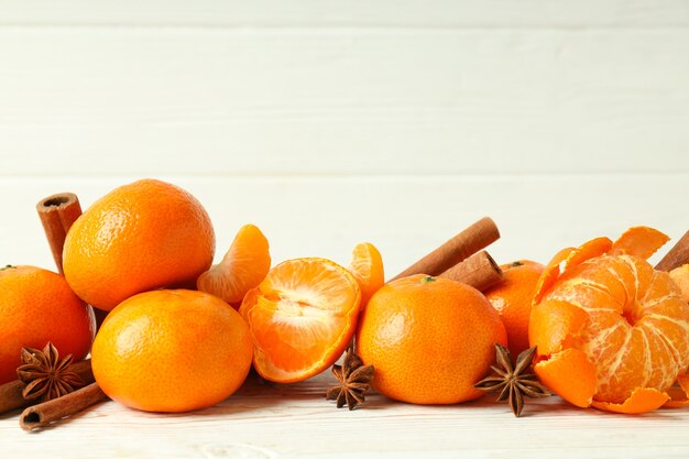 Mandarini e cannella su tavola di legno bianco