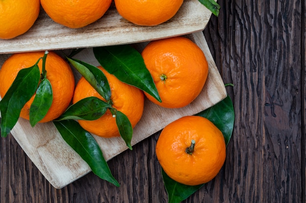 Mandarini freschi e crudi con foglie verdi.