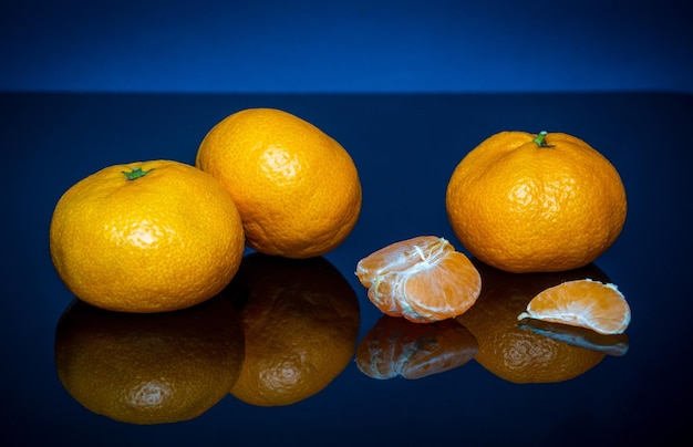 Mandarini gialli maturi o frutta mandarini su sfondo blu Idea clementine dieta