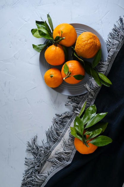 Mandarini in ciotole su superficie grigia