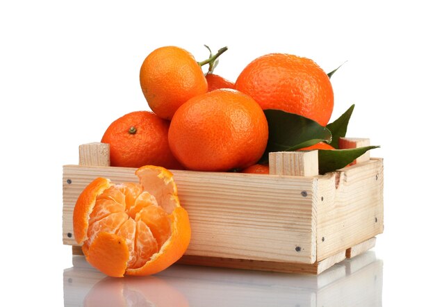 Mandarini saporiti maturi con le foglie in scatola di legno isolata su bianco