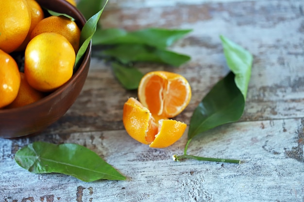 Mandarini succosi maturi con le foglie in una ciotola.