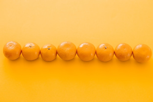 Mandarini succosi saporiti su sfondo giallo