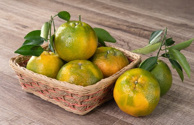 Mandarino fresco con foglie fresche sulla tavola di legno