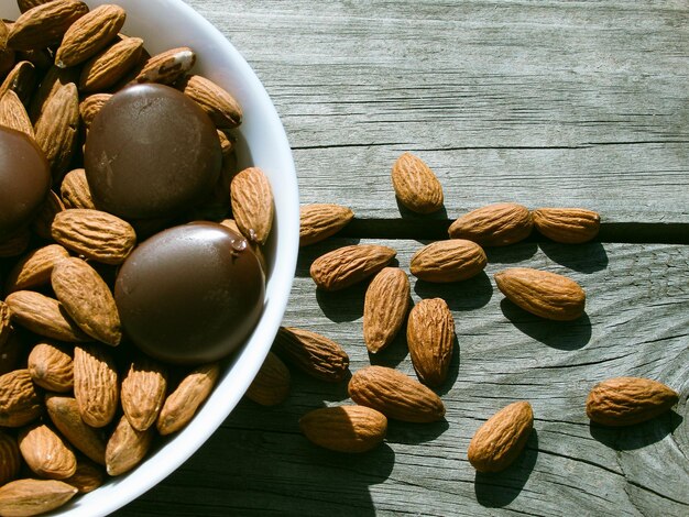 Mandorle e cioccolato fondente in una ciotola su un tavolo di legno Uno spuntino sano