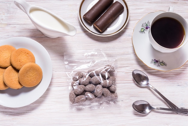 Mandorle in caramelle al cioccolato in borsa trasparente, sul tavolo di legno