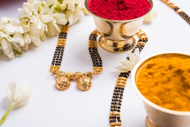 Mangalsutra o collana d'oro da indossare da una donna indù sposata, sistemata con sari tradizionale con huldi kumkum e fiori di mogra gajra, messa a fuoco selettiva