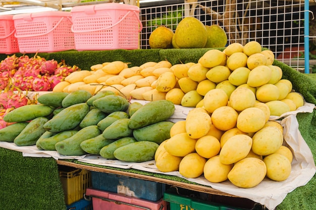 Manghi freschi gialli e verdi alla bancarella del mercato della frutta