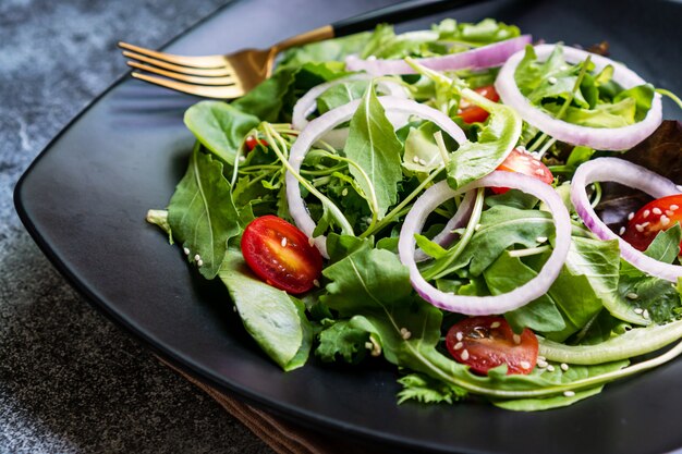 Mangi il concetto verde con l'insalata organica della verdura fresca in piatto ceramico.