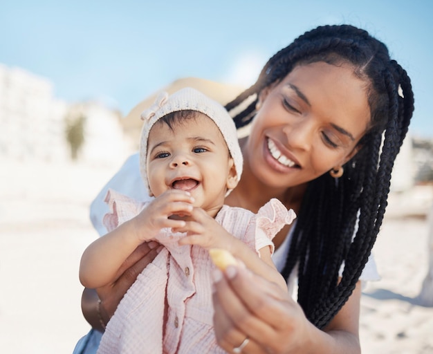 Mangia la mamma e il bambino in spiaggia come una famiglia felice durante un divertente picnic Rilassati o mangia in vacanza in Brasile Sorridi mamma e neonato si godono del tempo di qualità in riva al mare durante le vacanze estive