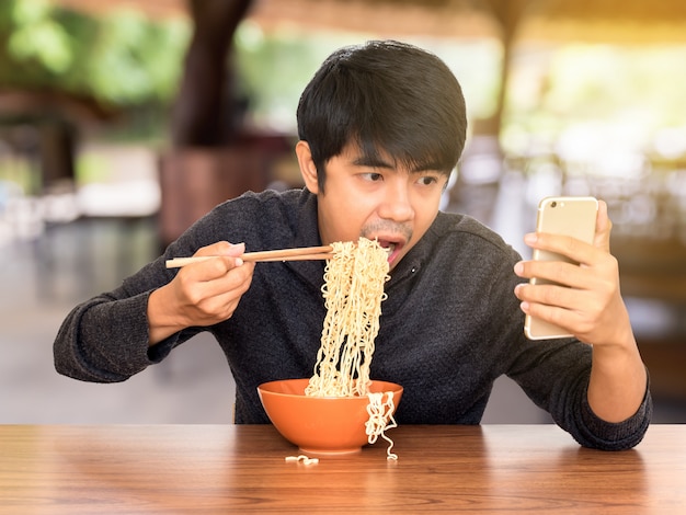 Mangia mentre si guarda e si usa lo smartphone