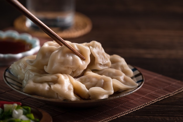 Mangiare freschi, deliziosi gnocchi bolliti, jiaozi sul fondo della tavola in legno con salsa di soia