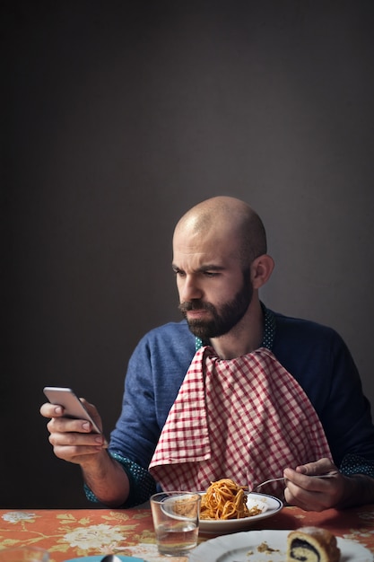 Mangiare la pasta e controllare il telefono