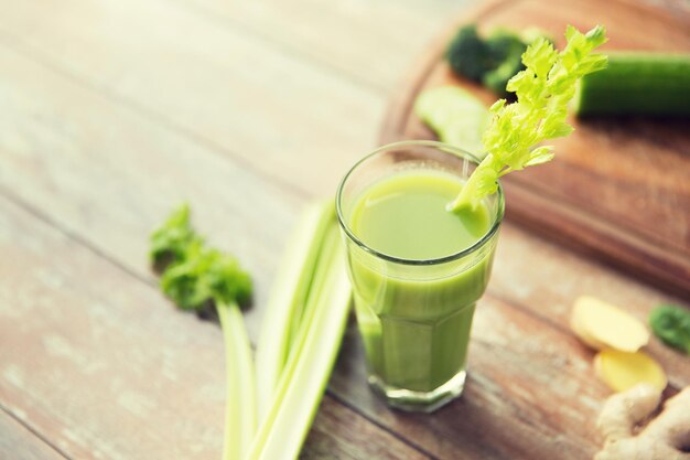 mangiare sano, cibo biologico e concetto di dieta - primo piano di succo verde fresco con sedano sul tavolo di legno