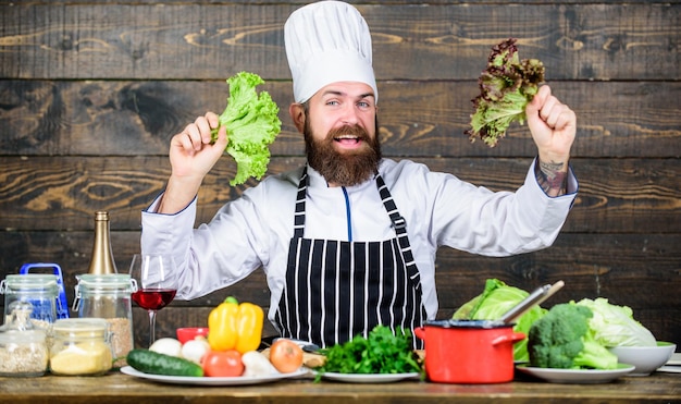 Mangiare sano concetto di dieta Uomo indossare cappello e grembiule tenere lattuga Alimentazione sana Hipster barbuto chef professionista tenere lattuga verde Ricetta vegetariana sana Ricetta cibo sano