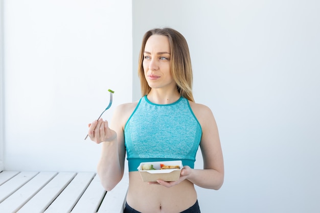 mangiare sano, dieta e concetto di fitness - giovane donna che mangia verdura e carne dopo l'allenamento