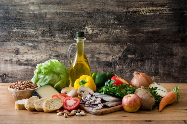 Mangiare sano. Dieta mediterranea Frutta a guscio cereali olio d'oliva e pesce sul tavolo di legno.