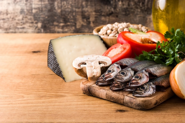 Mangiare sano. Dieta mediterranea Frutta, verdura, grano, olio di oliva matto e pesce sul tavolo di legno