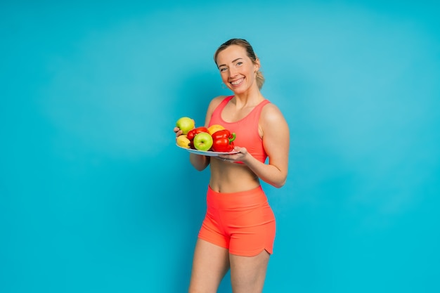 Mangiare sano, donna felice con frutta e verdura sta mangiando una mela