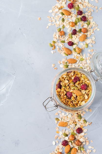 Mangiare sano e pulito, dieta e nutrizione, fitness, cibo equilibrato, concetto di colazione. Muesli di muesli fatti in casa con ingredienti su un tavolo. Vista dall'alto sullo sfondo dello spazio della copia piatta