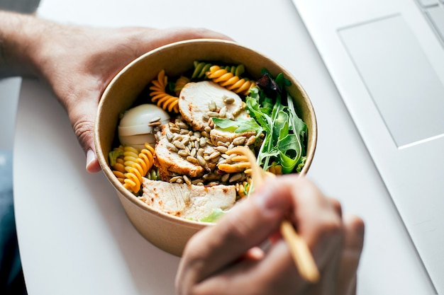 Mangiare sano pranzo ciotola nelle mani dell'uomo. Ministero degli Interni, consegna cibo, disintossicazione, concetto di cibo