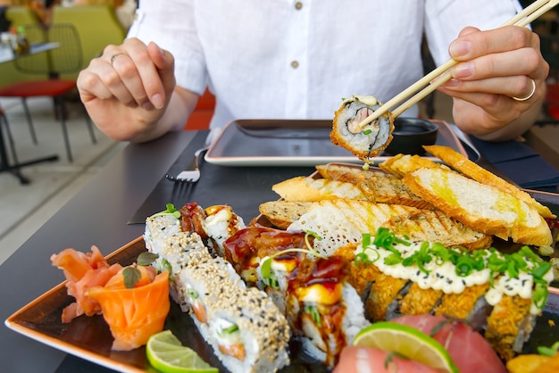 Mangiare sushi con le bacchette al ristorante di sushi