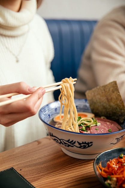 Mangiare zuppa di noodle giapponese shoyu ramen con le bacchette