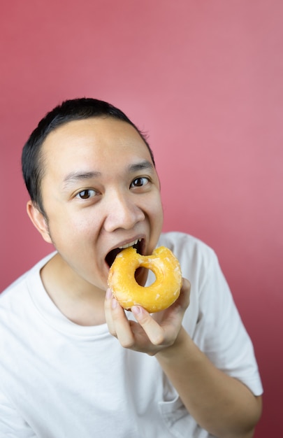 Mangiatore di uomini asiatico una ciambella deliziosa