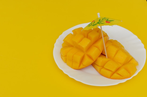 Mango affettato servito in piatto bianco su sfondo colorato