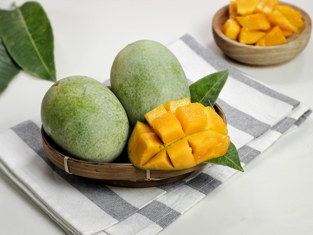 Mango fresco - Cubetti di mango tritati succosi su una ciotola di legno. Concetto di estate tropicale. Messa a fuoco selettiva