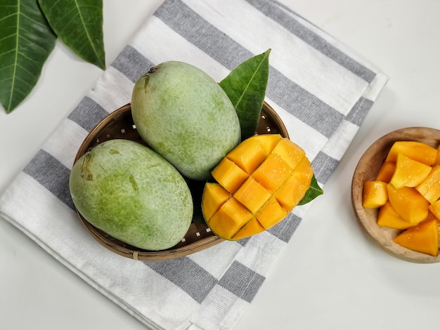 Mango fresco - Cubetti di mango tritati succosi su una ciotola di legno. Concetto di estate tropicale. Messa a fuoco selettiva