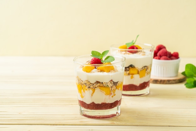 mango fresco fatto in casa e lampone fresco con yogurt e muesli - stile di cibo sano