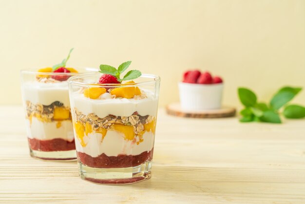 mango fresco fatto in casa e lampone fresco con yogurt e muesli - stile di cibo sano