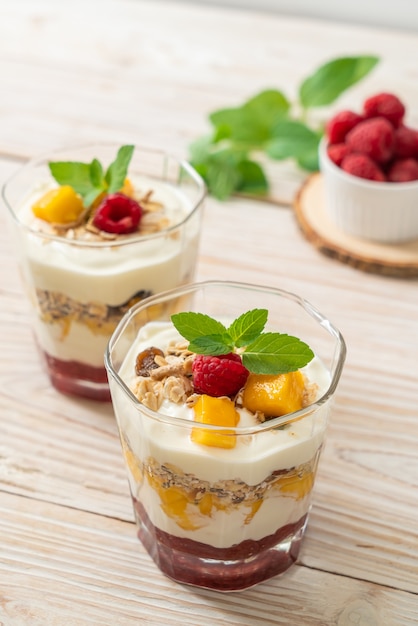 mango fresco fatto in casa e lampone fresco con yogurt e muesli - stile di cibo sano