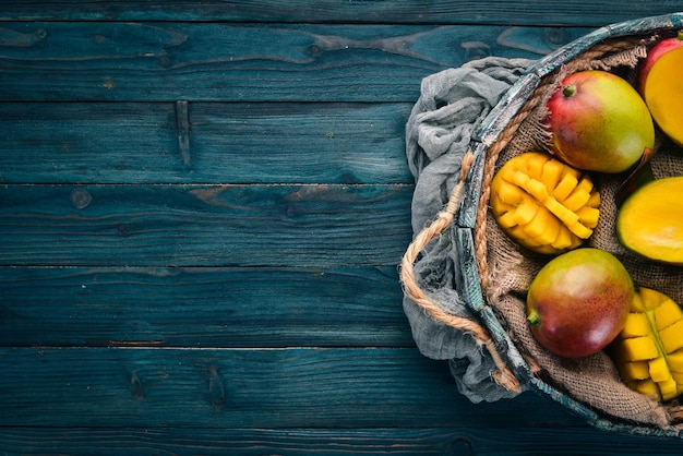 Mango fresco in una scatola di legno Su uno sfondo di legno Frutti tropicali Vista dall'alto Spazio libero per la copia